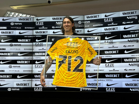 Cssio segura uma placa com a camisa comemorativa aos seus 712 jogos pelo Corinthians