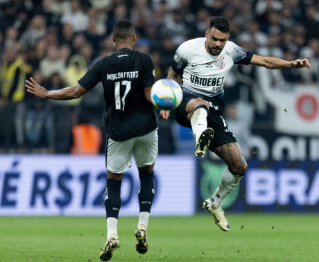 Raniele saltando para chutar a bola em dividida com jogador do Botafogo